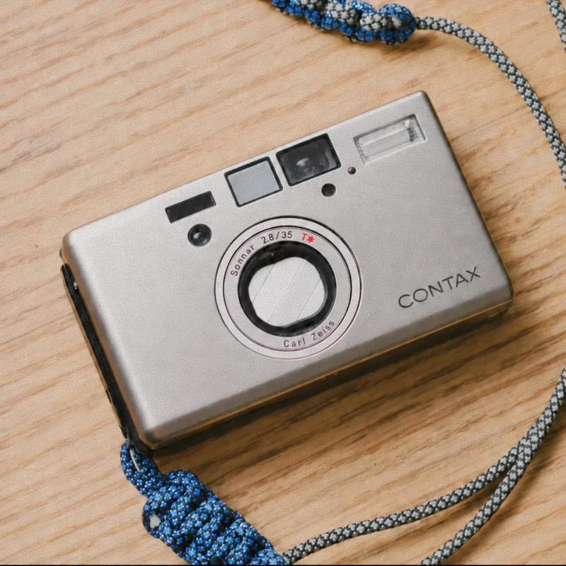 Silver Contax T3 camera with a blue strap
