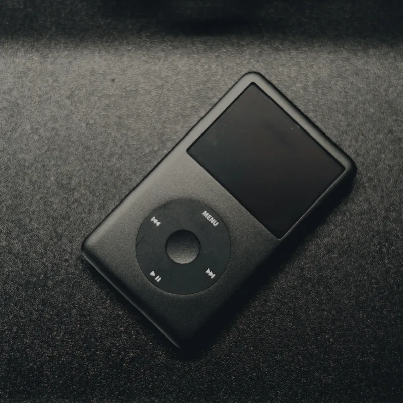 Black iPod Classic with a click wheel on a dark surface